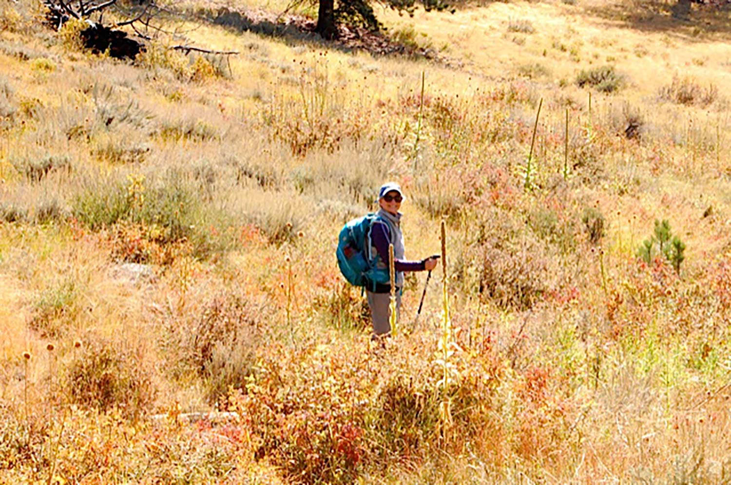 Cathy in hiking gear in a prairie